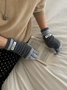 Close-up of cozy knitted touchscreen gloves with grey contrast and branded labels
