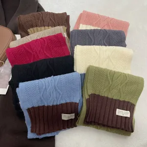 Close-up of cable knit patterns and woven labels on various colorful winter scarves