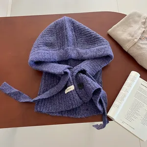 Texture détaillée du tricot de la cagoule en laine violette avec bouton noir décoratif