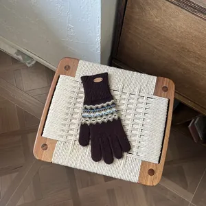 Detailaufnahme von Fair-Isle-Strickhandschuhen mit blau-grünem geometrischem Muster