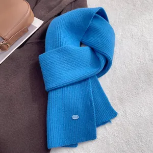 Detail of glacier blue ribbed 100% wool scarf with elegant oval decorative button detail