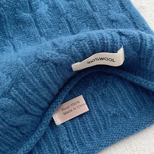 Detail der 100 % Wollmaterial- und klassischen Zopfstrickstruktur der blauen Mütze