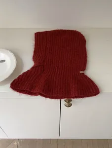 Detail der dunkelroten Balaclava mit flauschiger Mohair-Textur und beigem Stoffetikett