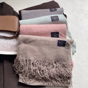 Primo piano di sciarpe in cashmere con nappe impilate con eleganti accessori invernali
