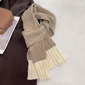 Detailed knit texture of coffee and cream beige thick winter scarf on cozy background
