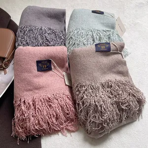 Sciarpe spesse effetto cashmere con nappe in quattro colori su fondo in peluche bianco