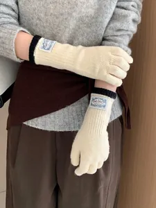 Close-up of knit glove cuff with black ribbed trim and branded logo tag detail