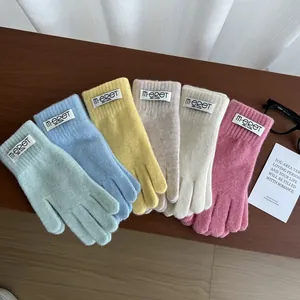 Close-up of candy-colored knitted gloves in macaron shades like mint and lemon yellow