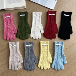 Flat lay of nine colors merino wool gloves featuring knitted diamond cable patterns