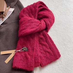 Detail shot of wine red chunky cable knit wool scarf with premium textured weave