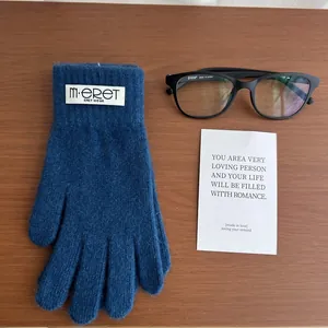 Detail of dark blue knit glove with brand label on rustic wood background