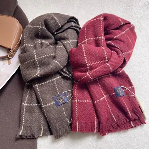 Detailed view of plaid cashmere scarf with soft tassels and brand label textures