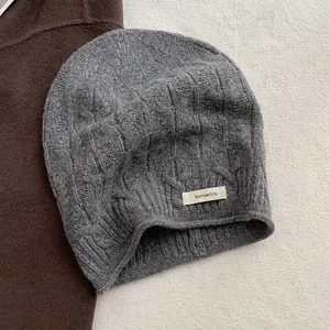 Detail einer Beanie aus 100% reiner Wolle mit klassischem Zopfmuster in hellem Grau