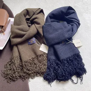 Dettaglio di sciarpe pesanti effetto cashmere in marrone scuro e blu navy con frange