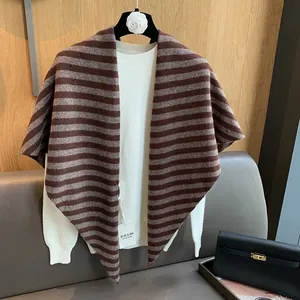 Detail of striped wool knit shawl in brown and beige with a handmade product tag