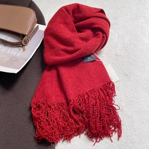 Dettaglio di sciarpa rossa con nappe, trama morbida e caldo materiale a maglia per l'inverno