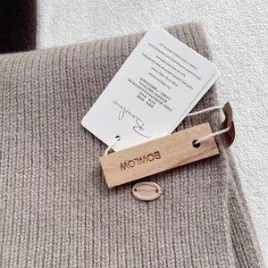 Detailed macro view of beige wool scarf featuring Banfane tag and BOWLOW wooden label