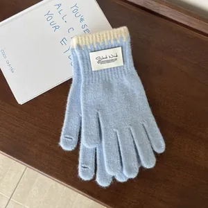 Detail of light blue knit glove with touchscreen fingertips and ribbed scalloped cuffs