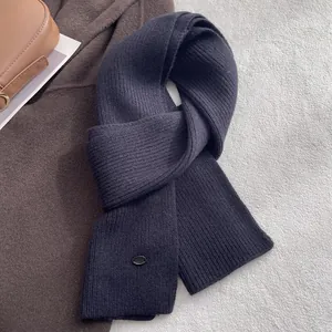 Detailaufnahme von dunkelblauem Wollstrickschal mit Rippenmuster und Metallschnalle