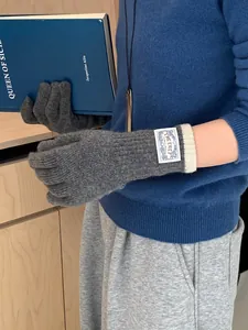 Detail of Korean style gray knit gloves with cream cuff and branded woven label