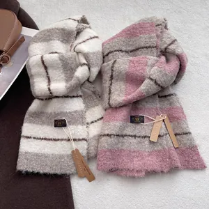 Detailaufnahme der Wollmischung-Streifenschals in Rosa und Grau mit weicher Textur