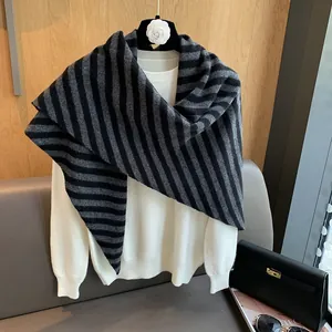 Detail of soft black and grey striped wool shawl draped over a white knit sweater