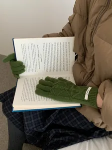 Detail of dark green merino wool knit gloves with touch screen design and cable pattern