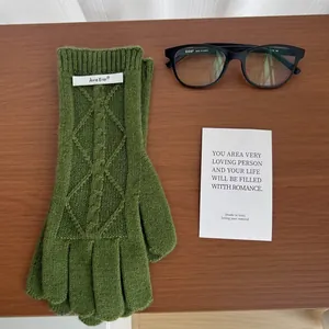 Flat lay of cable knit merino wool gloves in green with a vintage aesthetic look