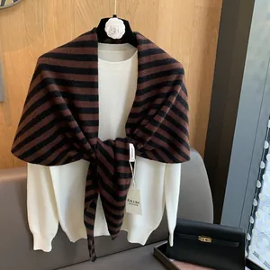 Close-up of 100% pure wool striped knit shawl showing refined texture and logo tag