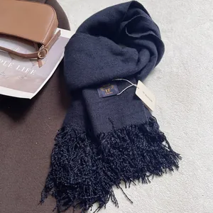 Dettagli della sciarpa pashmina spessa blu scuro con nappine ed etichetta del marchio