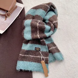 Detailansicht eines dicken gestreiften Wollschals mit Markenetikett und Strickstruktur