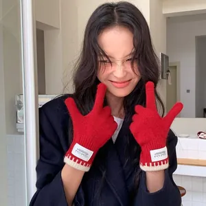 Soft red knit gloves for women with a contrast scalloped edge and a minimalist fabric label