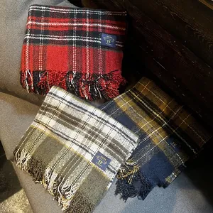 Détail d'écharpes à carreaux rayées avec bords à franges et étiquettes de marque
