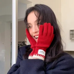 Vibrant red knit gloves for women featuring a stylish white label and ribbed cuffs