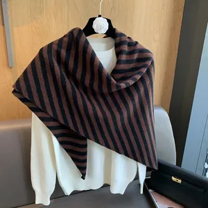 Detail showing high-quality wool knit shawl with brown and black stripes over a white top