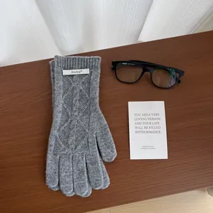 Detailed knit pattern on gray merino wool gloves with classic cable stitch design