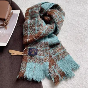 Close-up of thick blue and brown checkered scarf with soft tassels and woven brand label