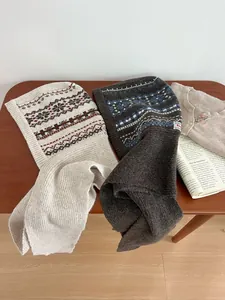 Detail of wool blend Balaclava scarf with Fair Isle patterns in cream and dark brown colors