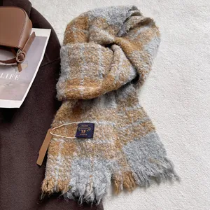 Detail of soft textured plaid scarf featuring fringe edges and YF BLOSSOM brand label