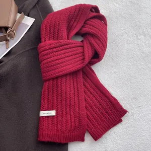 Dettaglio di sciarpa rossa in pura lana con etichetta tessuta su un cappotto invernale