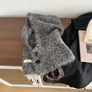 Detail van de boucle wollen bivakmuts met knoopsluiting en grijze gebreide structuur