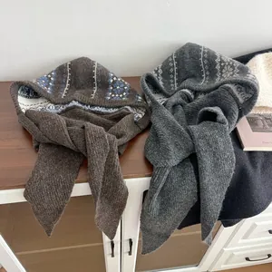 Detail of knitted Balaclava caps featuring Nordic patterns and long ties for winter warmth