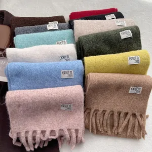 Soft wool-blend winter scarves in multiple colors with tassels and woven brand labels