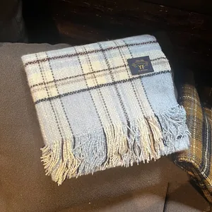 Détail de l'écharpe à carreaux bleus et blancs avec franges douces et étiquette tissée