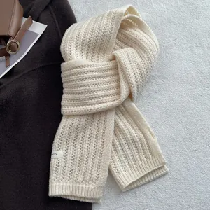 Dettaglio di una sciarpa in maglia a coste in 100% pura lana con etichetta in tessuto