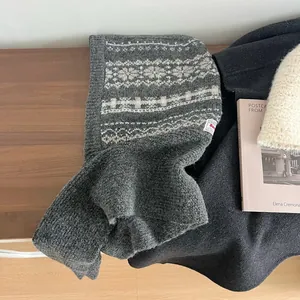 Close-up of Fair Isle knit balaclava with geometric patterns on a rustic wooden table