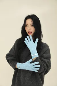 Detailed knit texture and cable pattern on light blue merino wool gloves for women