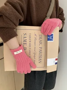 Pink wool gloves with wavy cuffs and screen-touch fingertips shown in a fashion setting