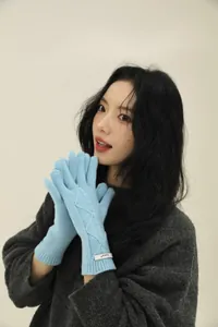 Detail of light blue merino wool gloves featuring a diamond knit pattern and woven tag