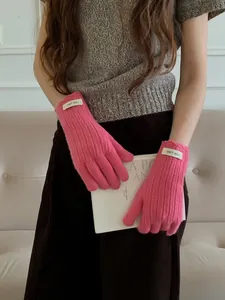 Detail of rose pink wool knit gloves featuring warm ribbed texture and scallop edge wrist